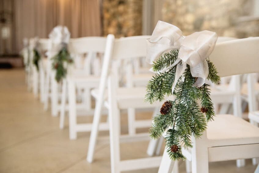 close up white resin chair decorated with mistletoe